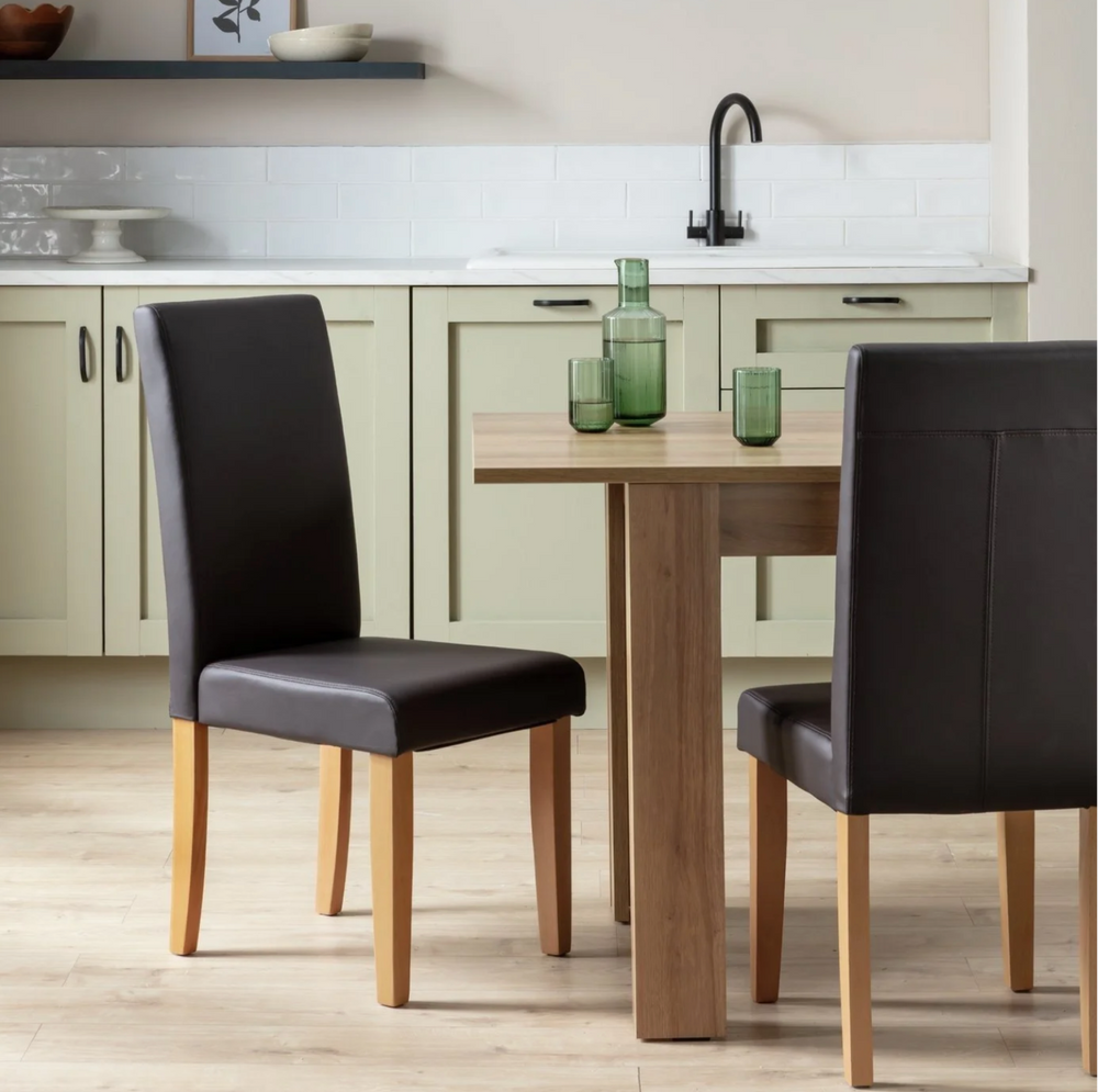 Pair of chocolate faux leather dining chairs with solid wood legs
